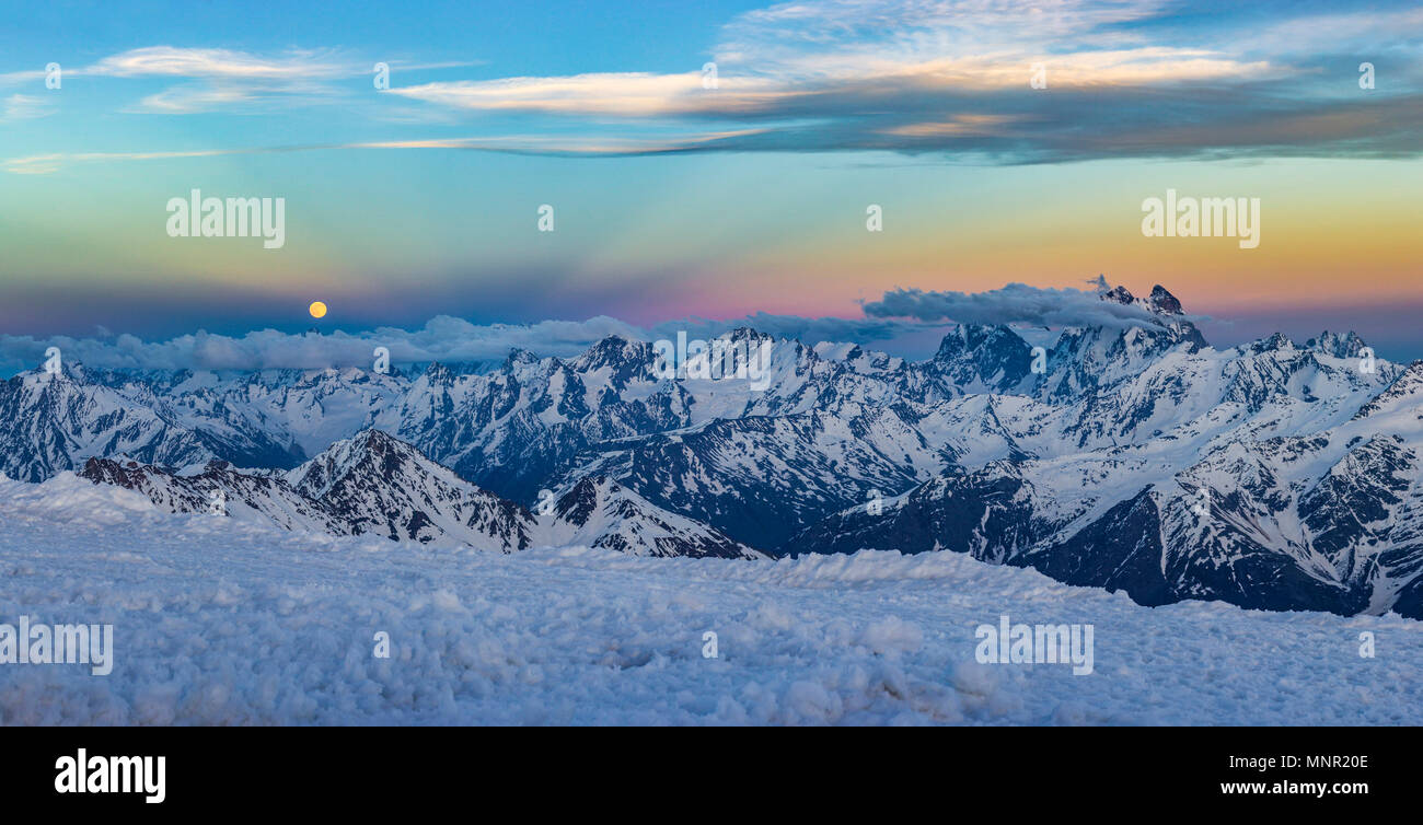 Caucaso innevate montagne con ghiacciai al tramonto da elbrus pendii con pietre e nuvole sul cielo blu Foto Stock