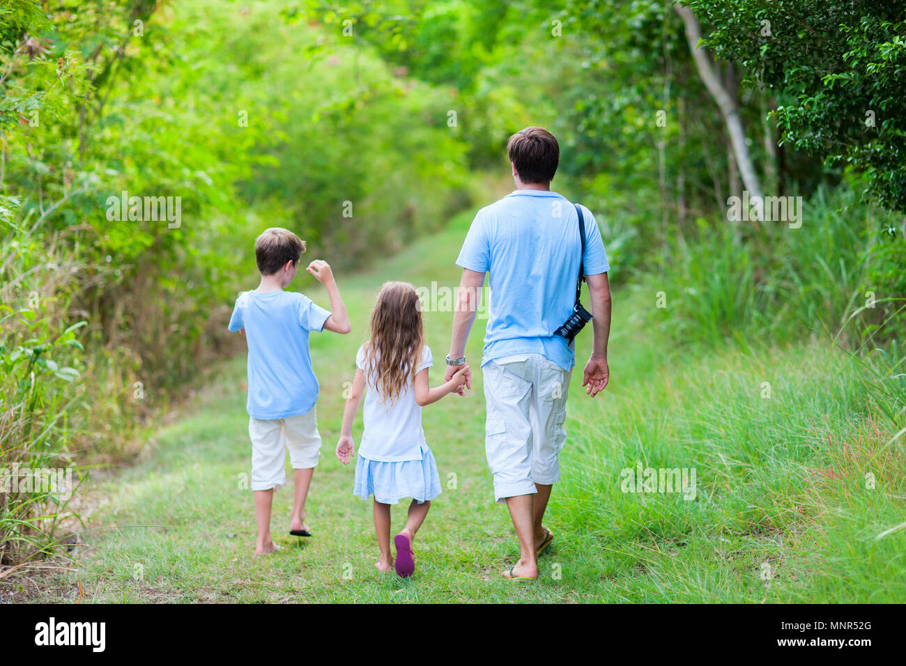 La famiglia del padre e bambini escursioni in foresta o parco al giorno di estate Foto Stock