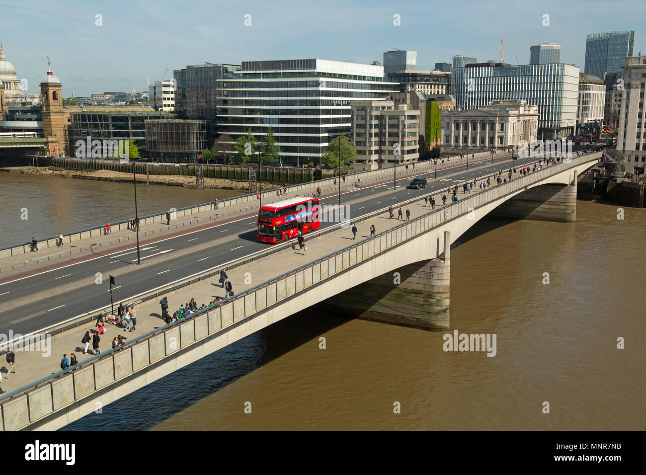 London Bridge visto dal lato sud, oltre il Fiume Tamigi, con rosso London double deckers autobus e pedoni. Foto Stock