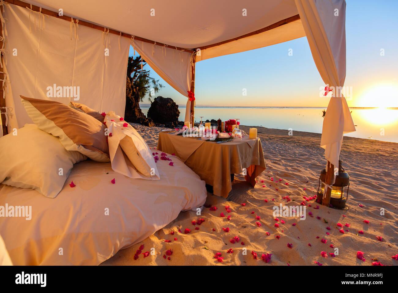 Romantica cena di lusso impostazione alla spiaggia tropicale sul tramonto Foto Stock