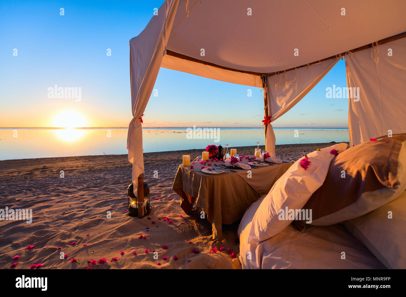 Romantica cena di lusso impostazione alla spiaggia tropicale sul tramonto Foto Stock