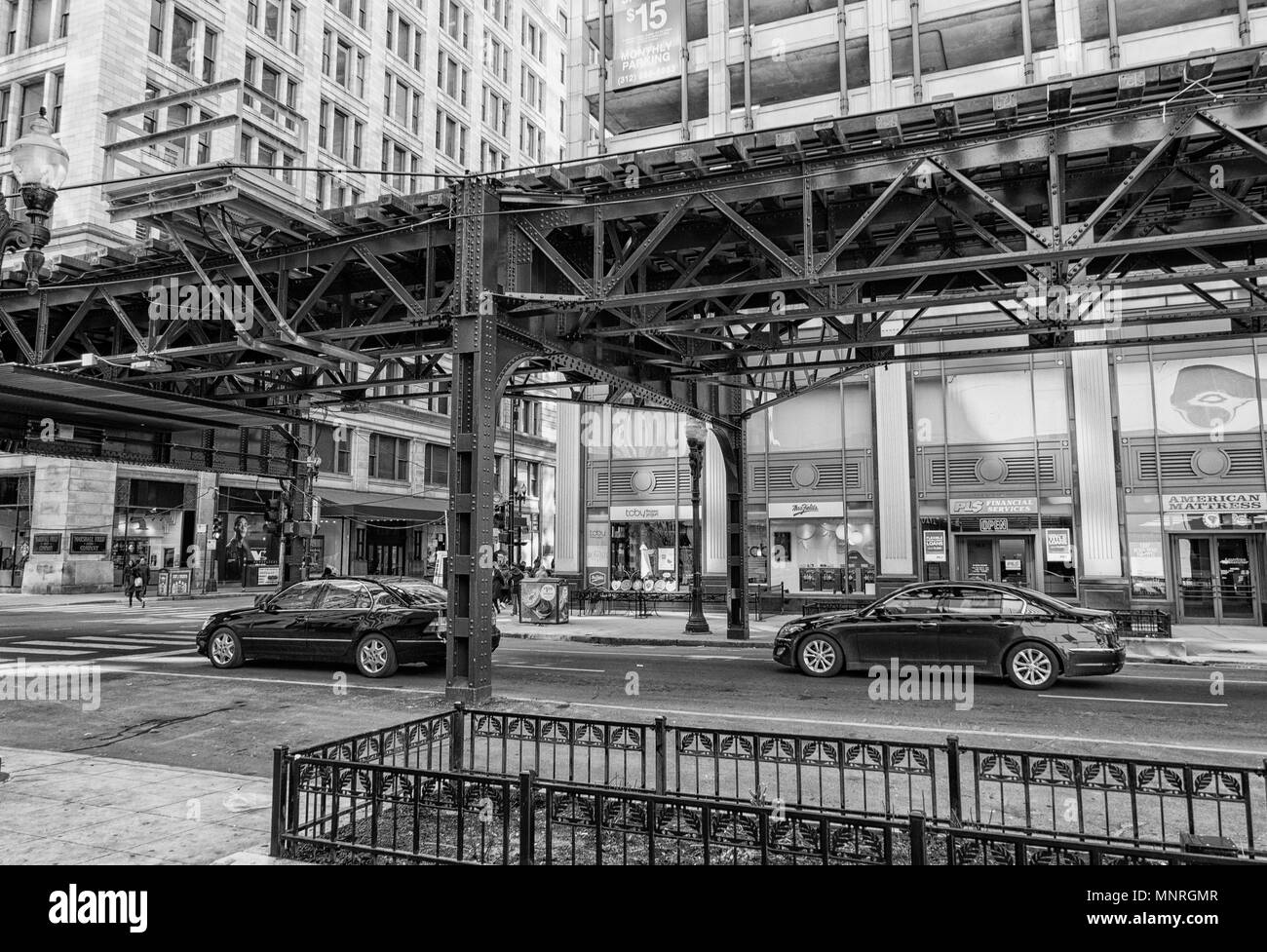 Treno di elevata via l'esecuzione di loop down street a Chicago, Stati Uniti d'America in bianco e nero Foto Stock