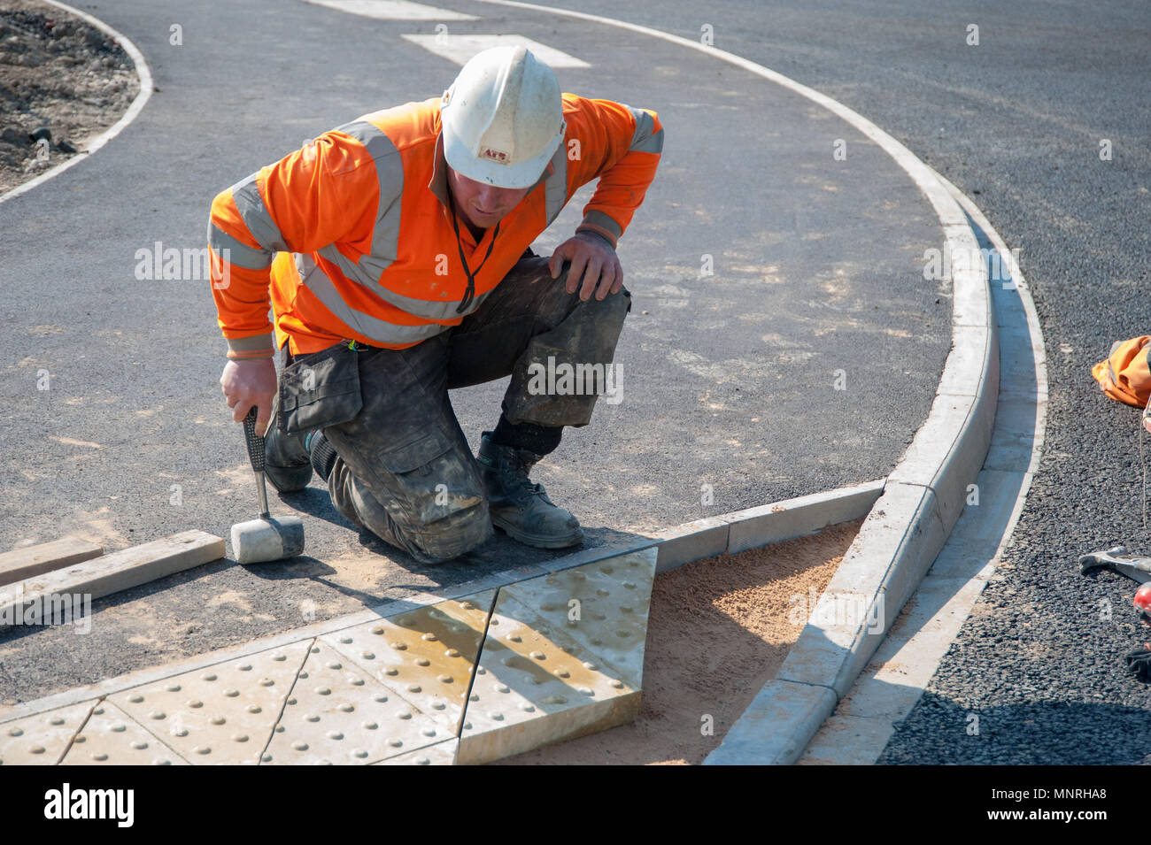 Workman posa di pavimentazioni Foto Stock