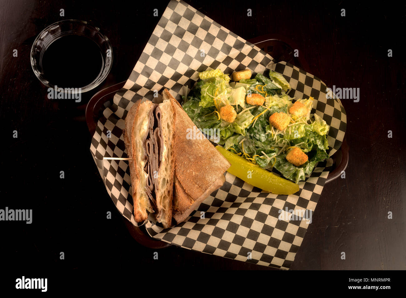 Ristorante sandwich in un cestello con la carta a quadretti e insalata mista Foto Stock