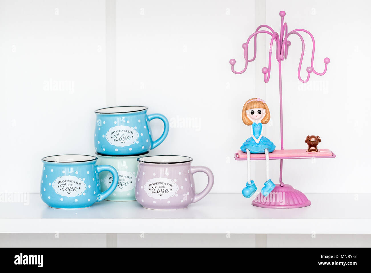 Ceramiche colorate tazze con lo smalto guardare sul ripiano bianco Foto Stock