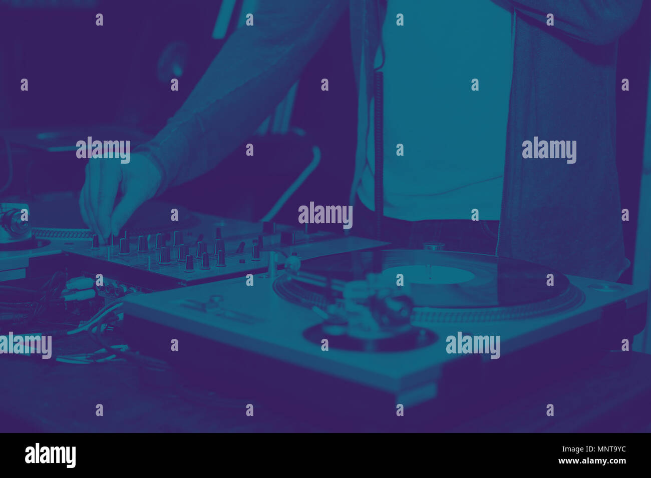 Dj mix di tracce a parte su vinile record giocatore. L'effetto bicromatica - blu e a ultravioletti Foto Stock