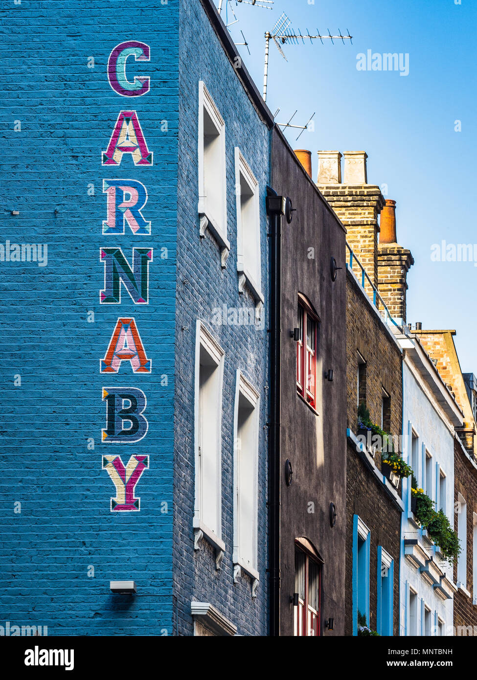 Carnaby Street London - segno dipinto sul lato di un edificio a Londra nel quartiere di Soho, Carnaby è famoso come il cuore della Swinging London nel 60s Foto Stock