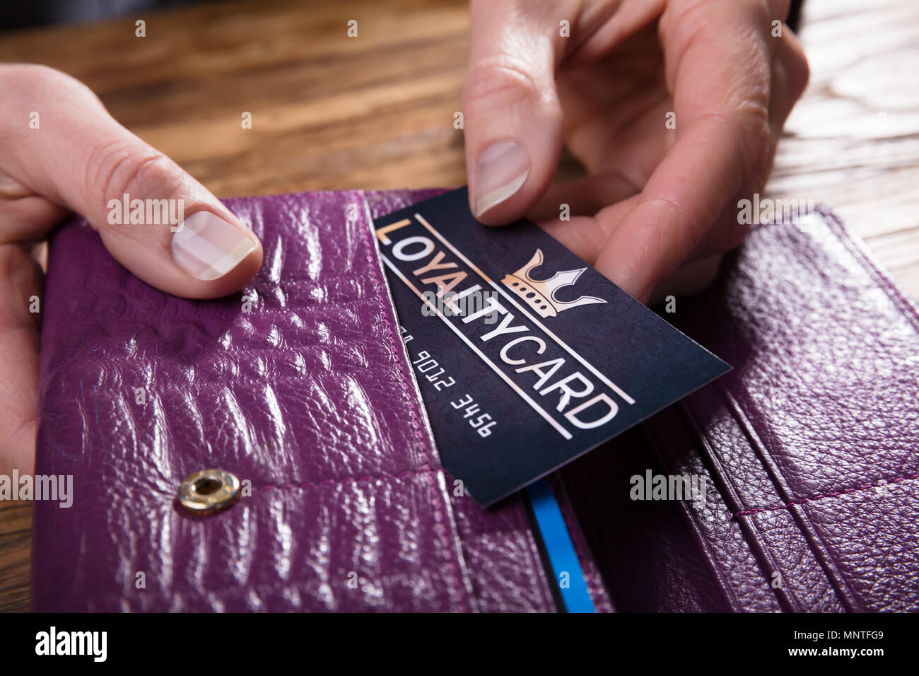 Close-up di un imprenditore la mano rimozione della carta fedeltà da borsa Foto Stock