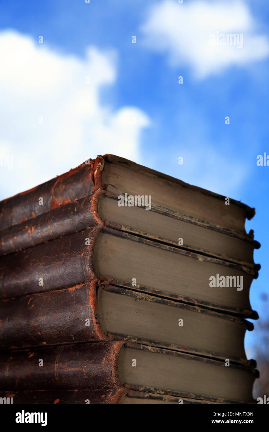 Pila di libri vecchi sul cielo azzurro sfondo con spazio libero Foto Stock
