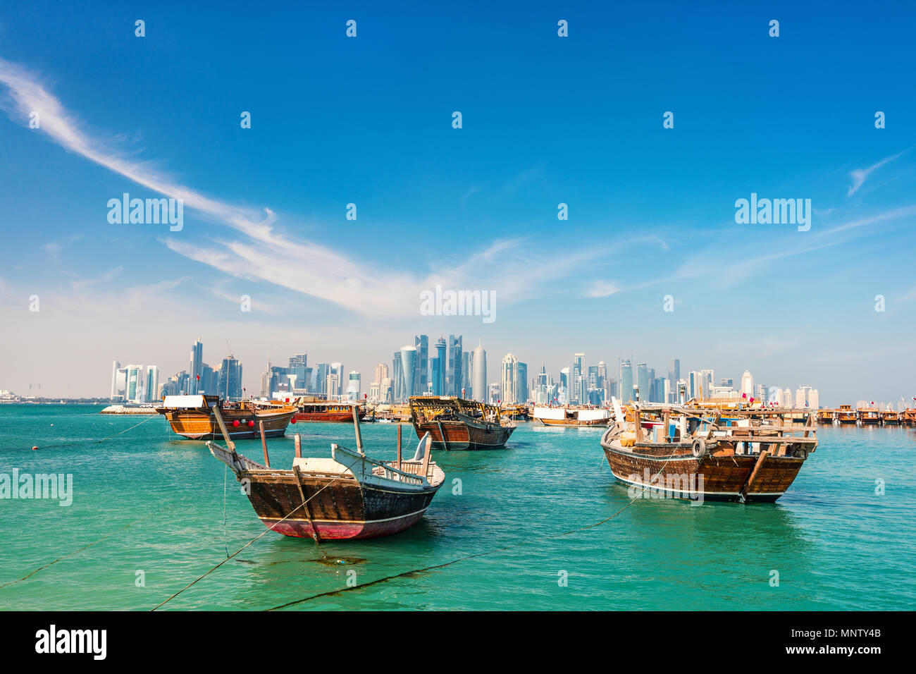 Waterfront a Doha in Qatar con legno tradizionali di piccole navi noto come dhow e dello skyline della città Foto Stock