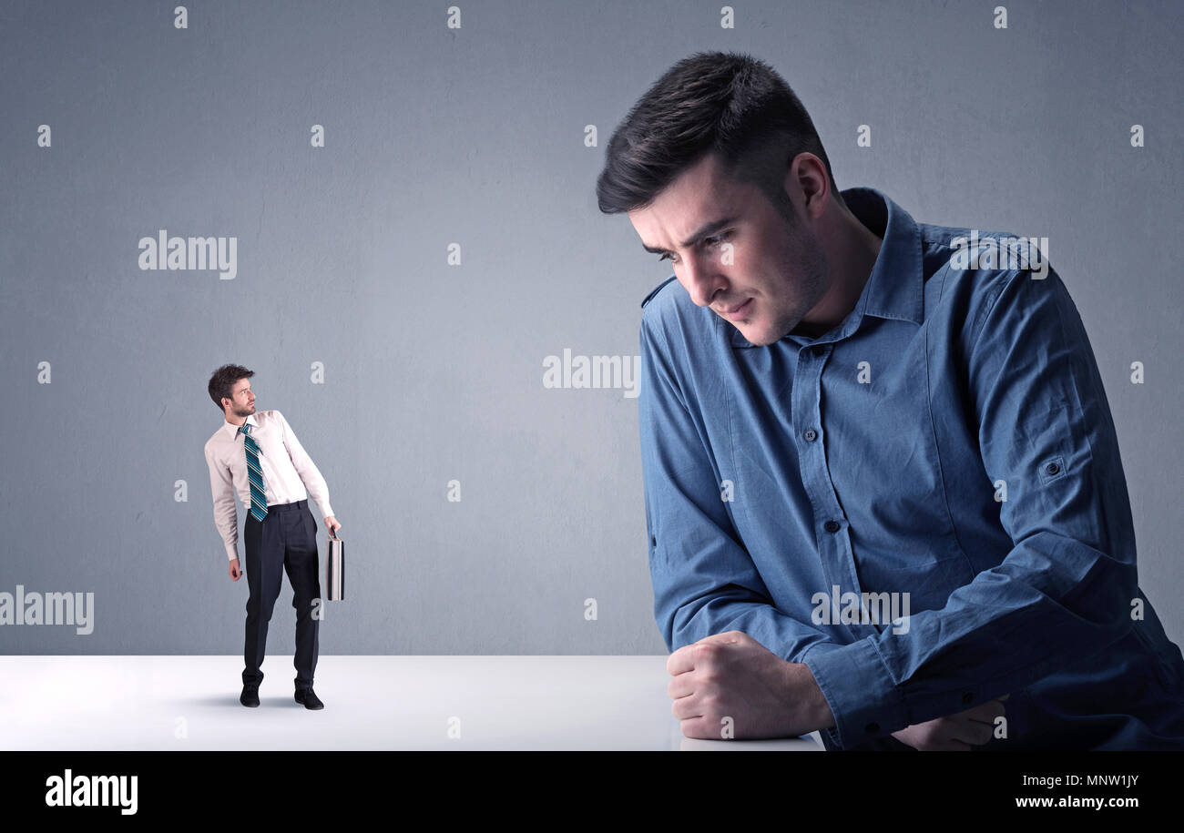 Giovane imprenditore professionale essendo arrabbiato con un altro imprenditore in miniatura Foto Stock
