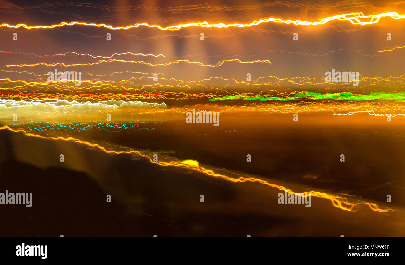 Una lunga esposizione da un aereo in movimento trasforma luci dell'aeroporto in striature di colore. Foto Stock