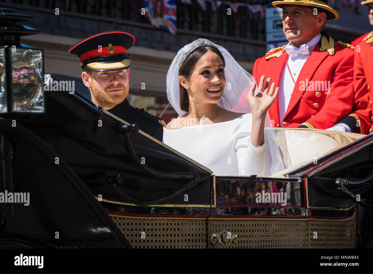 Windsor, Regno Unito, 19 maggio 2018. Il principe Harry e la sua sposa Meghan Markle ride in giro per le strade di Windsor in uno stato di Landau accolto da una folla numerosa tifo e sventolando bandiere a seguito del loro matrimonio in cappella di St Georges. Prima di rientrare al Castello di Windsor per il loro ricevimento di nozze. Essi saranno ora sapere come il Duca e la Duchessa di Sussex Foto Stock