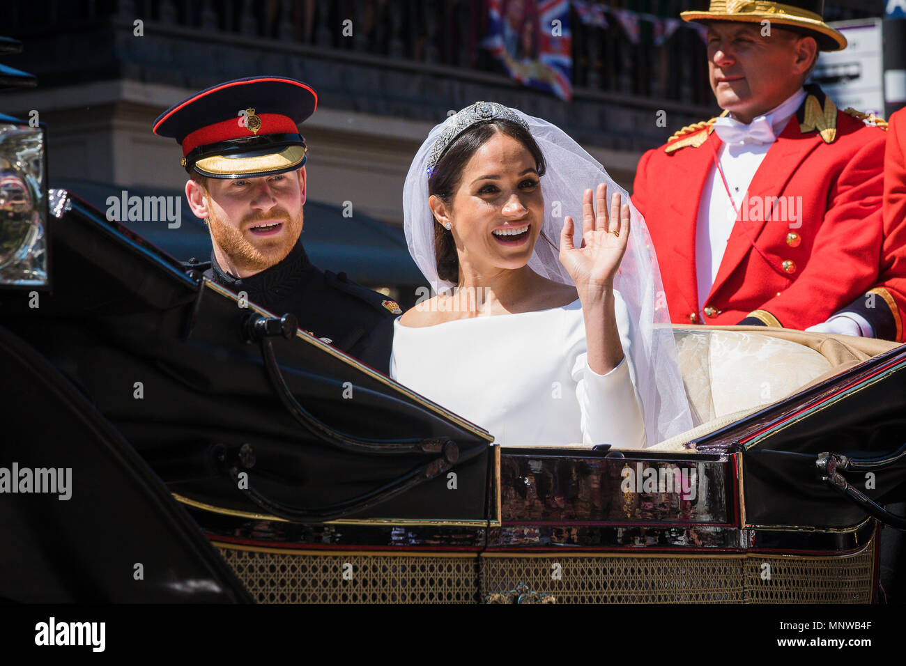 Windsor, Regno Unito, 19 maggio 2018. Il principe Harry e la sua sposa Meghan Markle ride in giro per le strade di Windsor in uno stato di Landau accolto da una folla numerosa tifo e sventolando bandiere a seguito del loro matrimonio in cappella di St Georges. Prima di rientrare al Castello di Windsor per il loro ricevimento di nozze. Essi saranno ora sapere come il Duca e la Duchessa di Sussex Foto Stock
