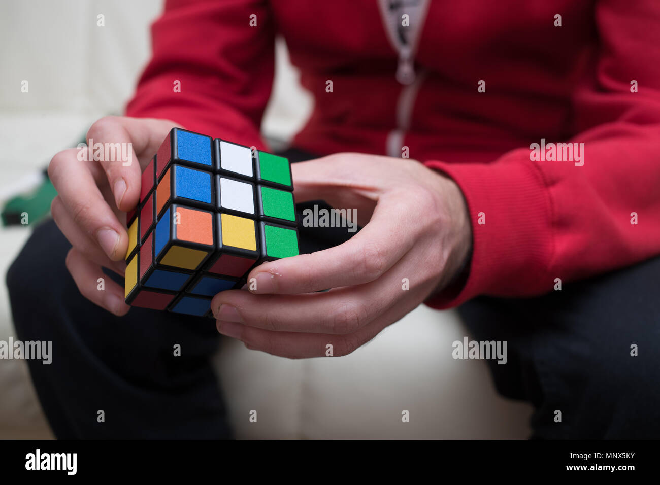 Le mani di un ragazzo di raccogliere un cubo colorato puzzle Foto Stock