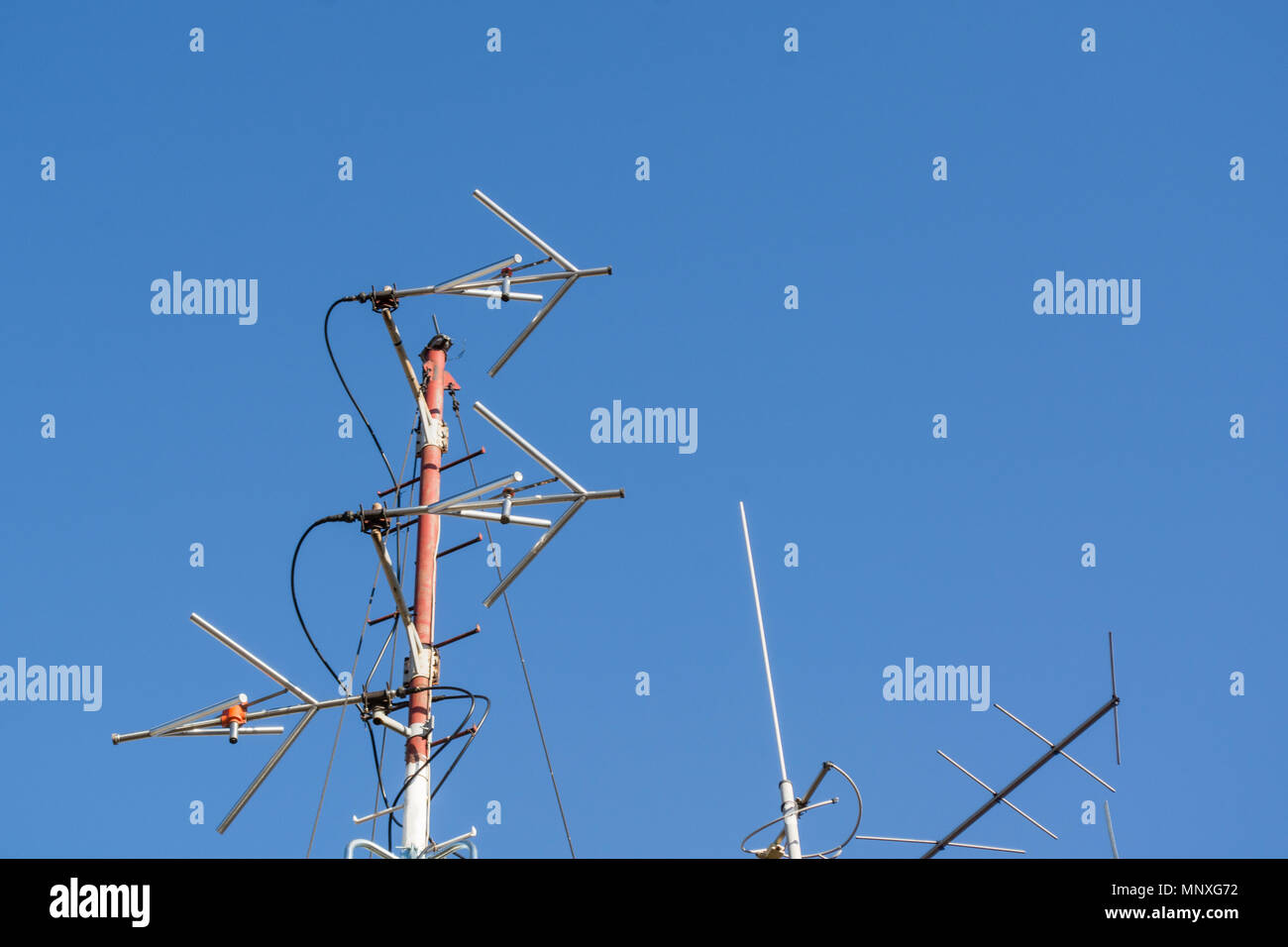 Professional Radio FM antenne per stazione radio sulla costruzione di tetto e cielo blu in background Foto Stock