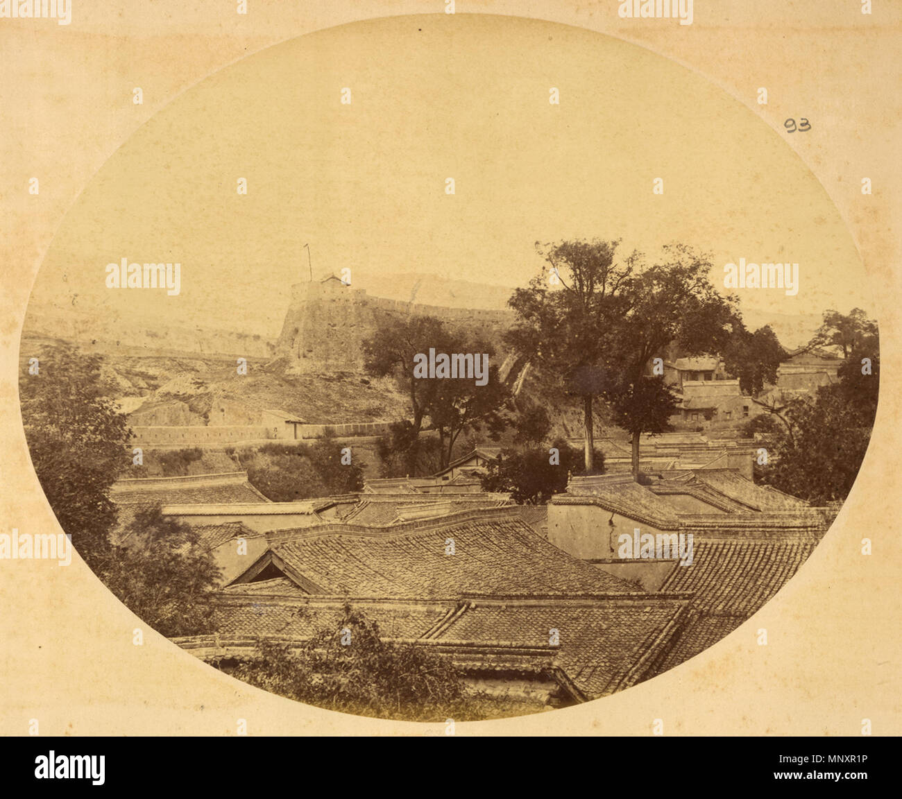 Русский: г. Циньчжоу, важный торговый пост и центр экспорта маньчжурских оленьих рогов, виднеется лишь одна наклонная крыша с приподнятым коньком. Провинция Ганьсу, Китай, 1875 г. Français : la ville de Qinzhou, grand Comptoir commercial et Centre d'exportation du bois de cerf mandchou ; photographie montrant des allasua à onu seul versanti avec une arête saillante. Provincia du Gansu en Chine, 1875 Inglese: la città di Qinzhou, una delle principali Trading Post e il Centro per l'esportazione di Manchurian corna di cervo, mostra un unico tetto spiovente con cresta rialzata. Provincia di Gansu, Cina, 1875 中文: 满洲鹿角的重要贸易站和出口中心秦州，可 Foto Stock