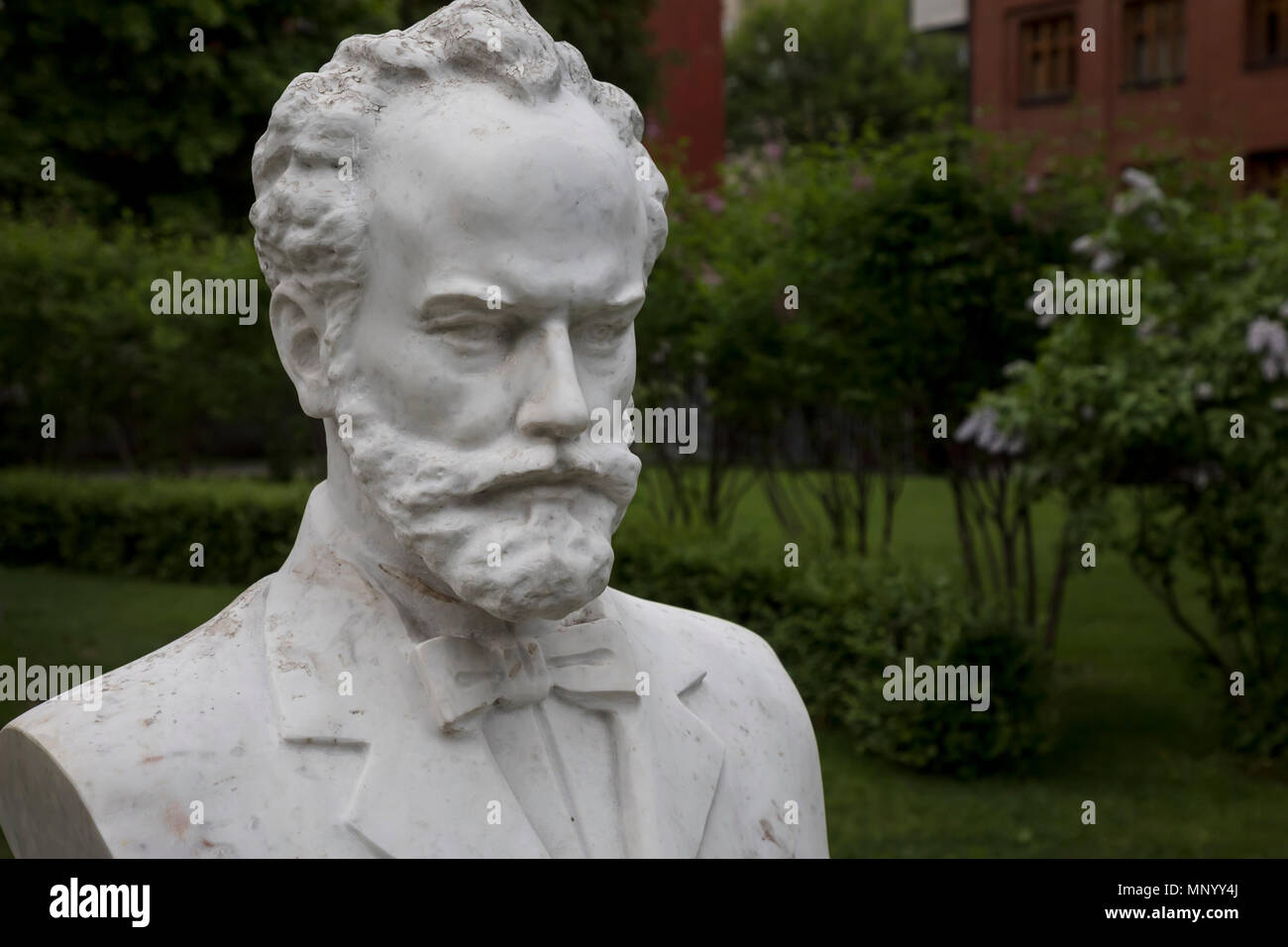 Un busto del compositore russo Piotr Ilyich Tchaikovsky è impostata nella parte anteriore del palco a cielo aperto nell'Eremo giardino nel centro di Mosca, Russia Foto Stock