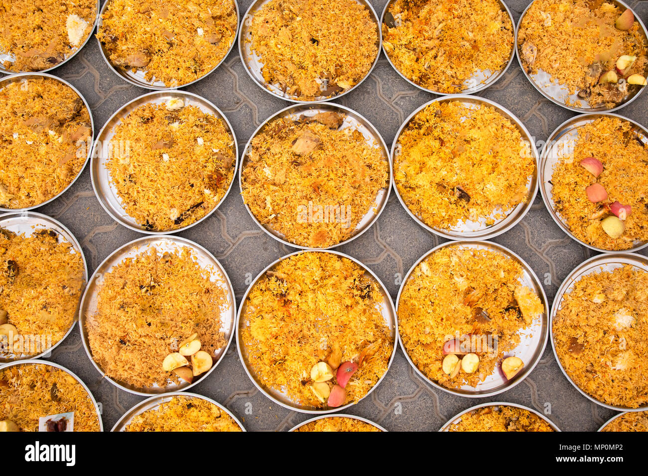 Piastre Birjani essendo preparato prima di essere distribuiti in una moschea locale come parte del Ramadan di carità. Dubai, EAU. Foto Stock