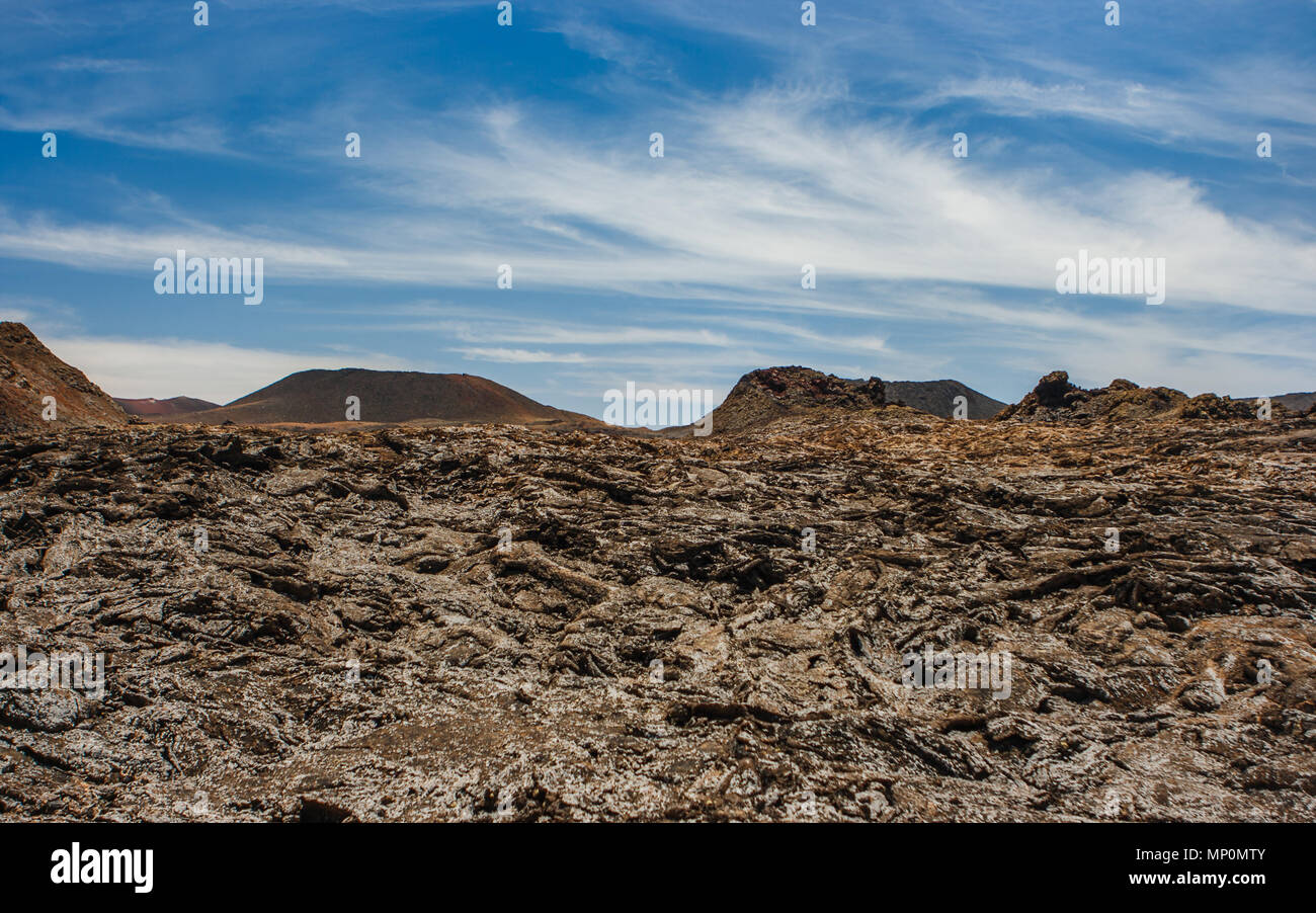 Vista panoramica di un cratere vulcanico nel Parco Nazionale di Timanfaya sotto un cielo blu con nuvole. Lanzarote, Isole Canarie, Spagna. Foto Stock