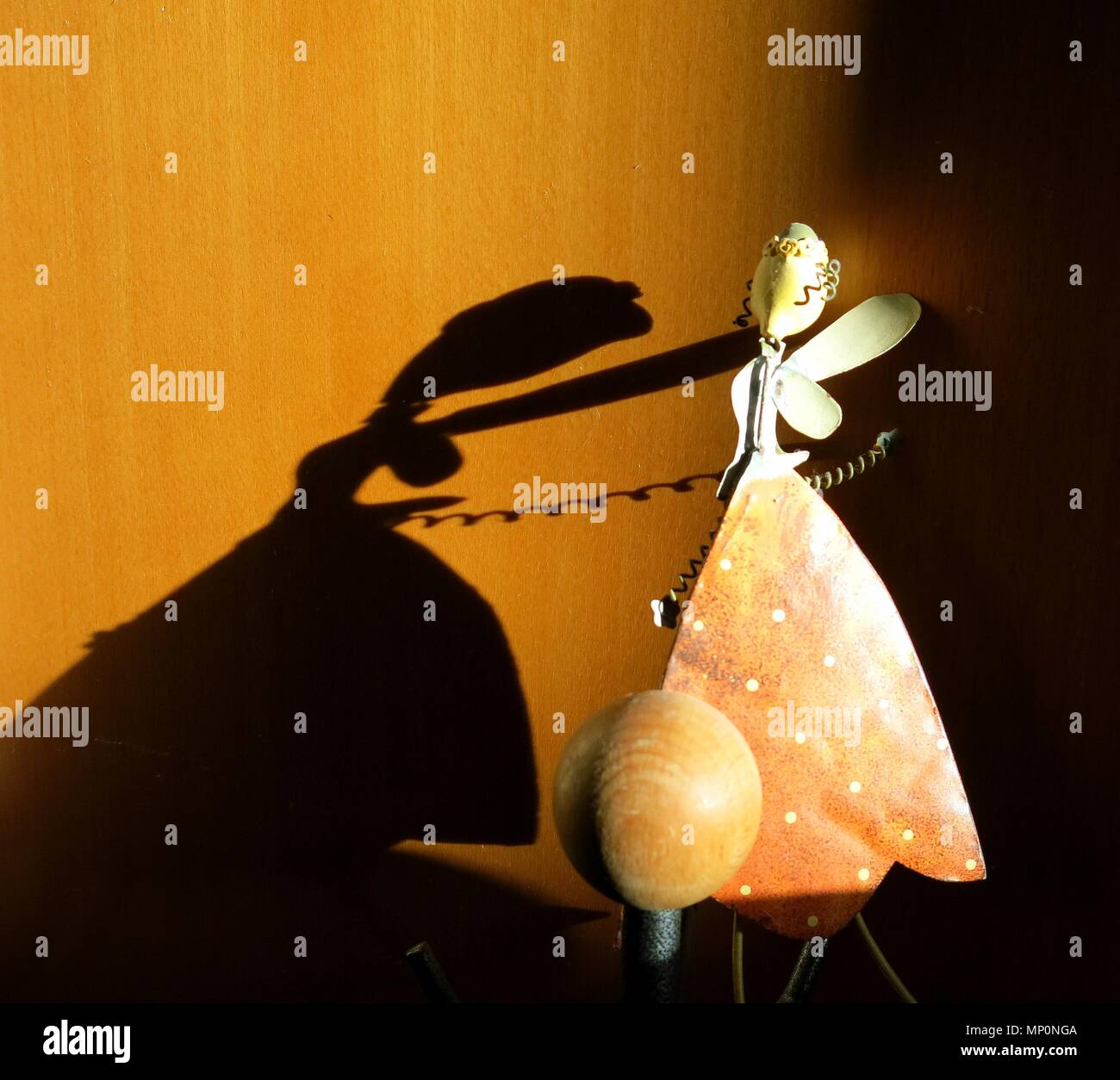 Fata figura gettando la sua ombra su armadio di legno. Concetto : luce e ombra nel minimalismo. Foto Stock