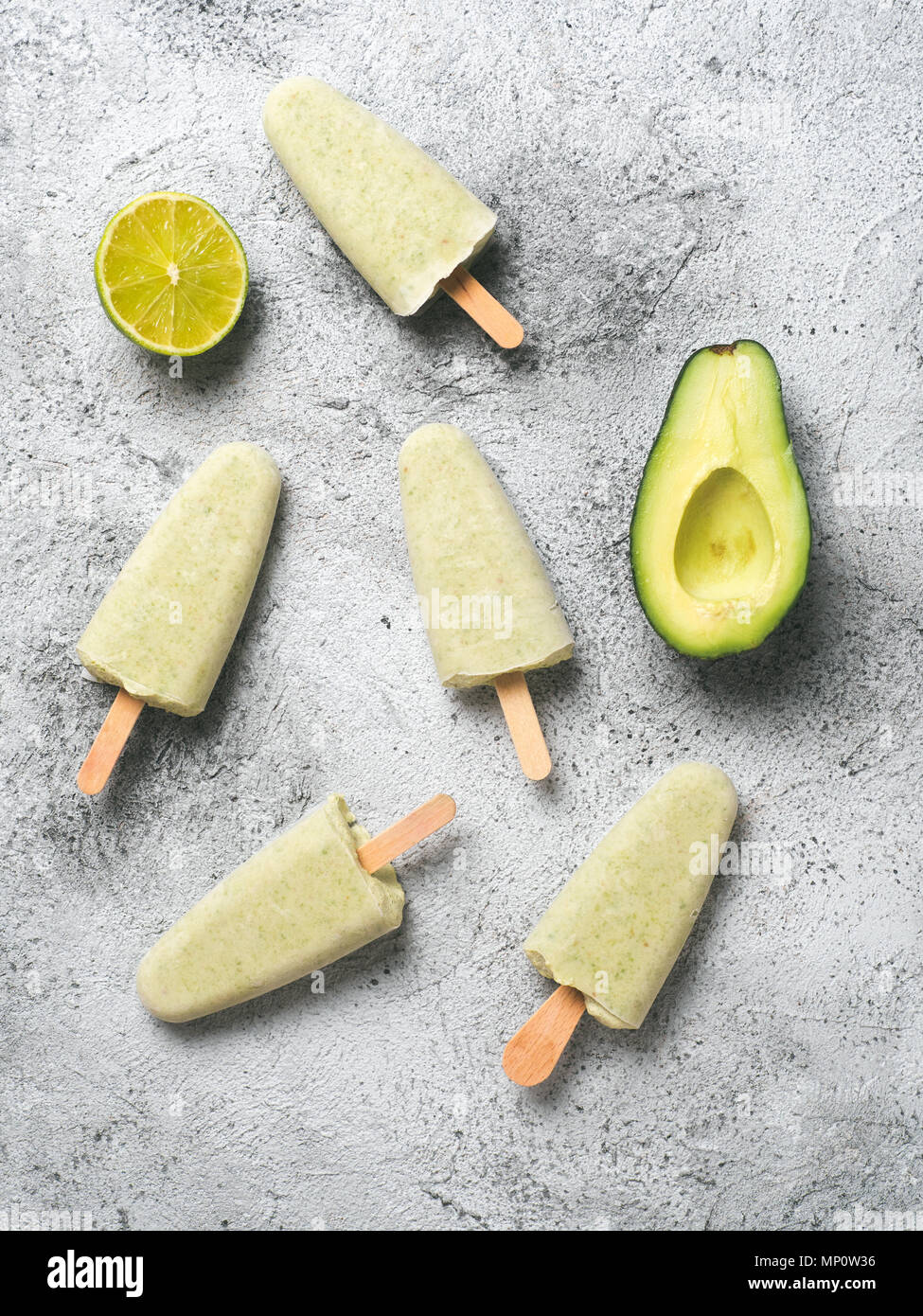 In casa materie vegane avocado lime ghiaccioli. Senza zucchero, non-dairy verde ice cream su sfondo grigio. Copia dello spazio. Vista dall'alto. Idee e ricette per snack sani, dessert o un frullato. Verticale. Foto Stock
