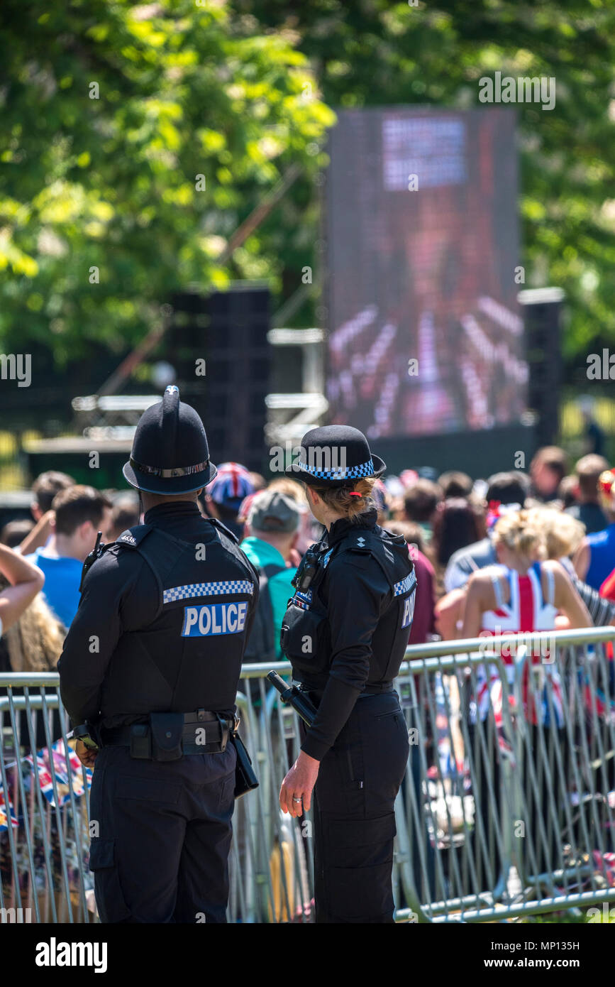 19 Maggio 2018 - gli ufficiali di polizia in stand by e guardare livestreams del Royal Wedding nel Castello di Windsor del principe Harry e Meghan Markle su TV di grandi dimensioni lungo il cammino. Foto Stock