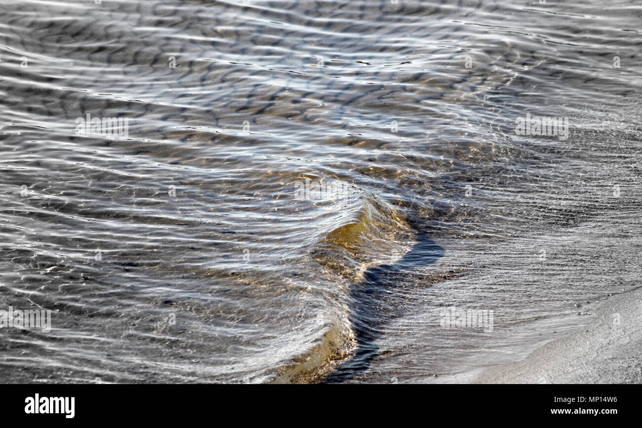 Close up di laminazione morbide onde sulla spiaggia sabbiosa Foto Stock