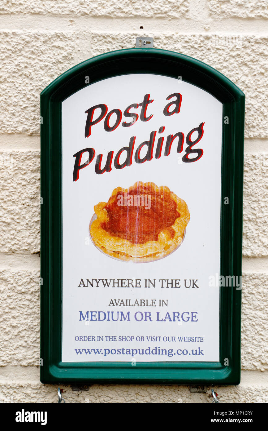 Post un budino; un annuncio in Bakewell che mostra in che modo è possibile inviare un Bakewell tart ovunque nel Regno Unito Foto Stock