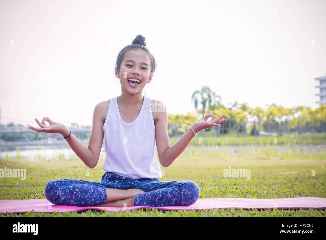 La ragazza la pratica dello yoga nel parco rafforza la concentrazione e la salute , Yoga per bambini divertirsi la meditazione delle attività per i bambini Foto Stock
