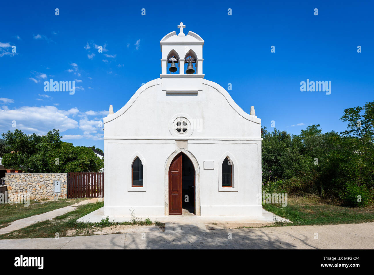Generic piccola vecchia chiesa sull'Isola di Silba in Croazia. Piccola chiesa bianca con campane, porte e finestre sulla piccola isola Croata Silba. Foto Stock