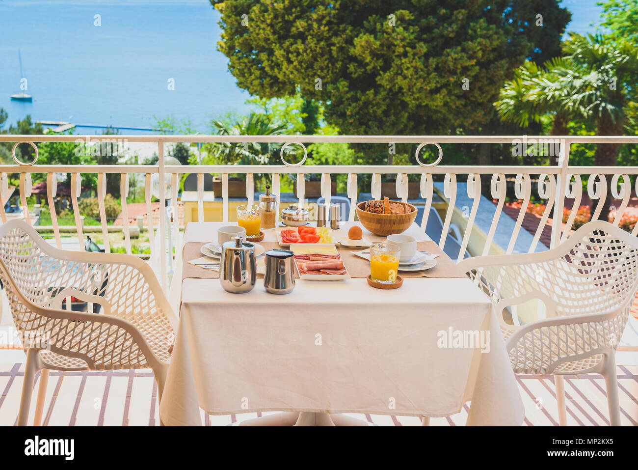 Continentale colazione di mattina messa in tavola con vista mare è servita. Hotel Ristorante prima colazione a buffet è servita su un terrazzo in prossimità dell'oceano. Vacanza Foto Stock