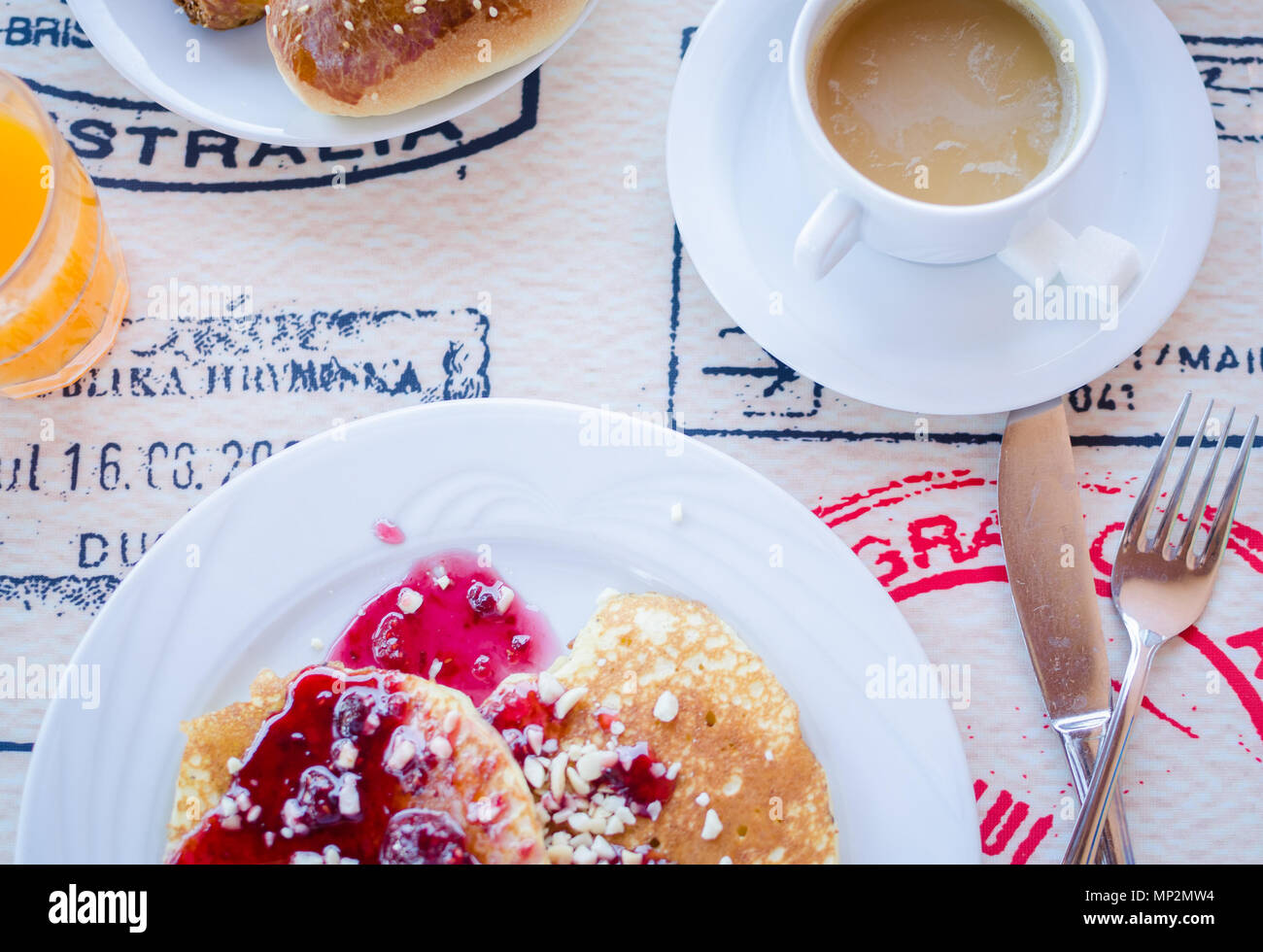 Prima colazione inclusa classic pancake con confettura di lamponi, caffè con latte e prodotti di pasticceria. Buona mattina. Vista dall'alto. Foto Stock