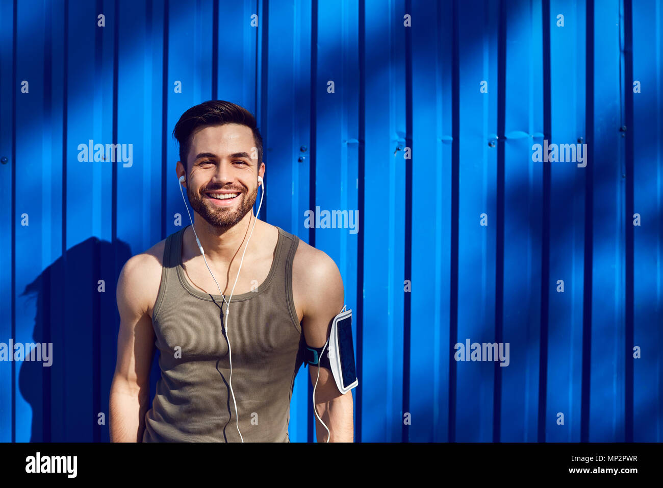 Un uomo con una barba atleta runner nelle cuffie. Foto Stock