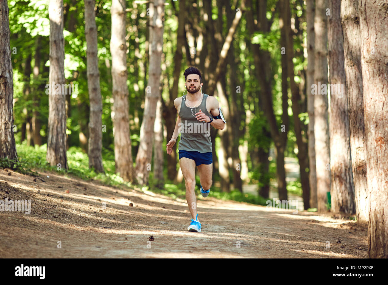 Un giovane maschio runner corre nella foresta. Foto Stock
