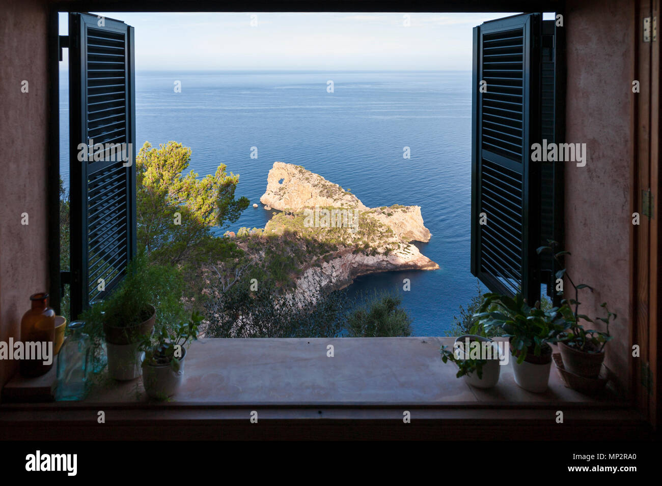Vista attraverso una finestra aperta della Punta de Sa Foradada penisola in Deia, Mallorca. Foto Stock