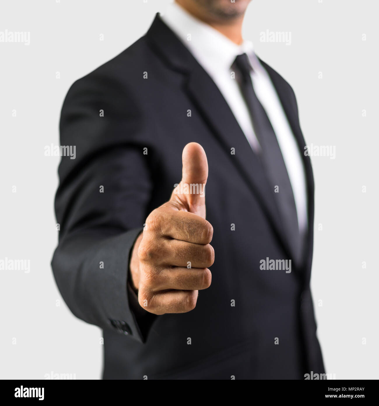 Happy businessman con il pollice in alto gesto, islated su sfondo grigio Foto Stock