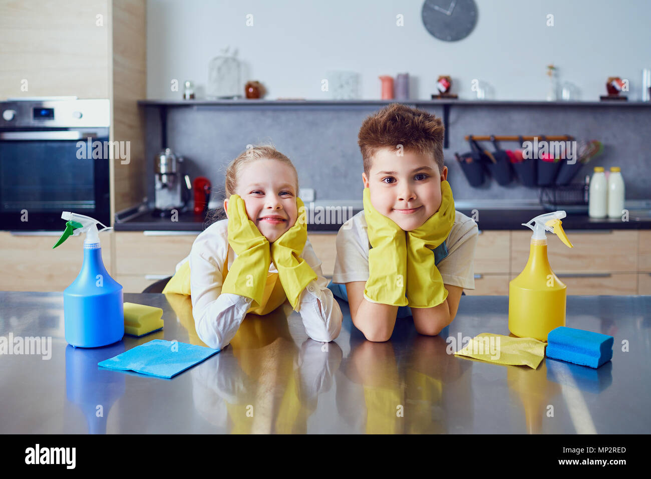 Bambini sorridenti fare pulizia in cucina Foto Stock