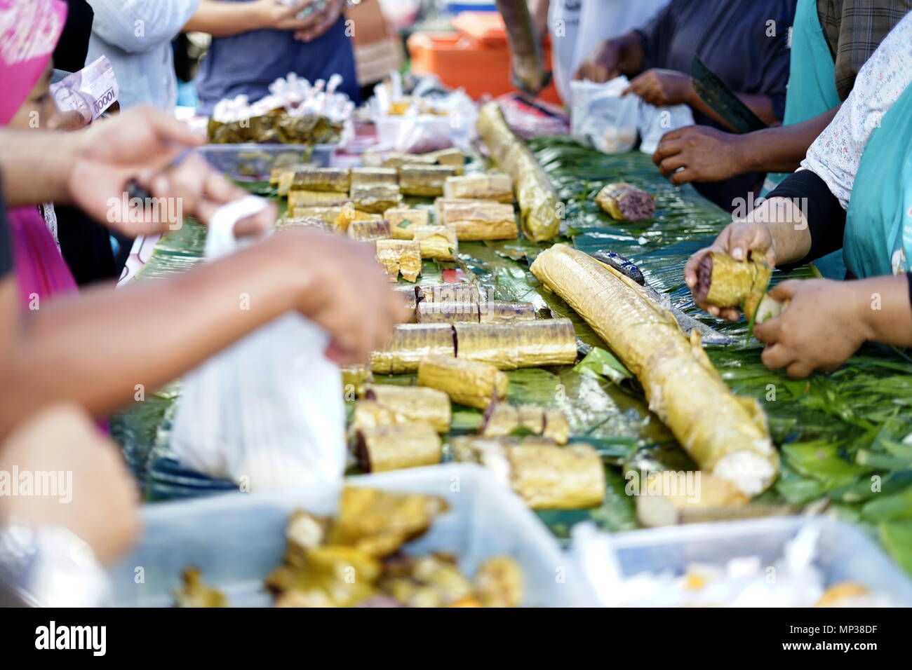 Persone che acquistano riso appiccicoso dessert in street market alimentare durante il digiuno del Ramadan al mese in Città di Banda Aceh, la provincia di Aceh, Indonesia Foto Stock