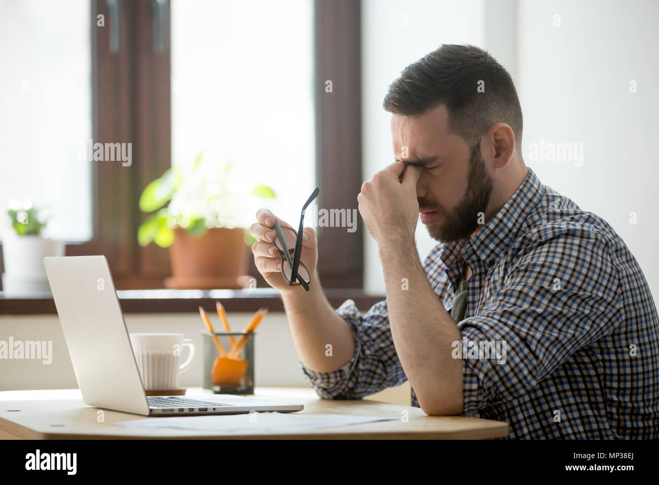 Ha sottolineato di massaggio maschio ponte nasale che soffrono di mal di testa Foto Stock
