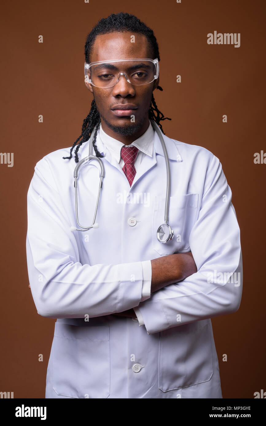 Bel giovane uomo africano medico indossando occhiali protettivi aga Foto Stock