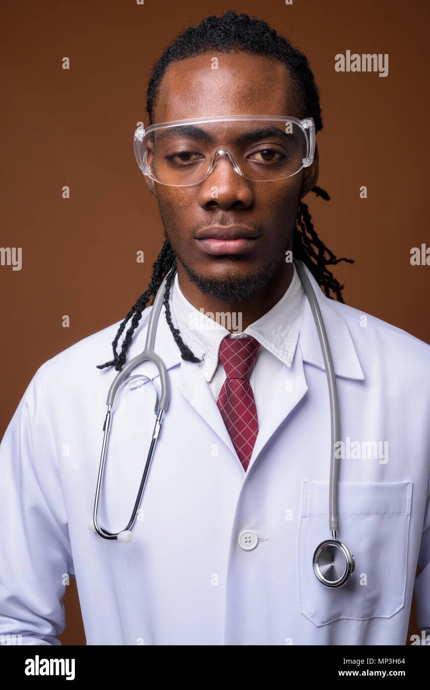 Bel giovane uomo africano medico indossando occhiali protettivi aga Foto Stock