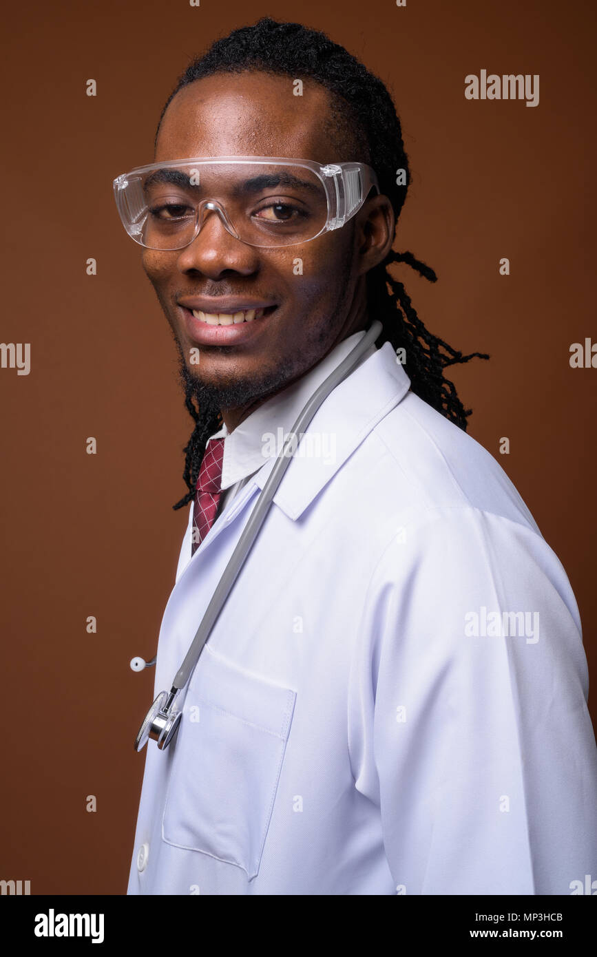 Bel giovane uomo africano medico indossando occhiali protettivi aga Foto Stock