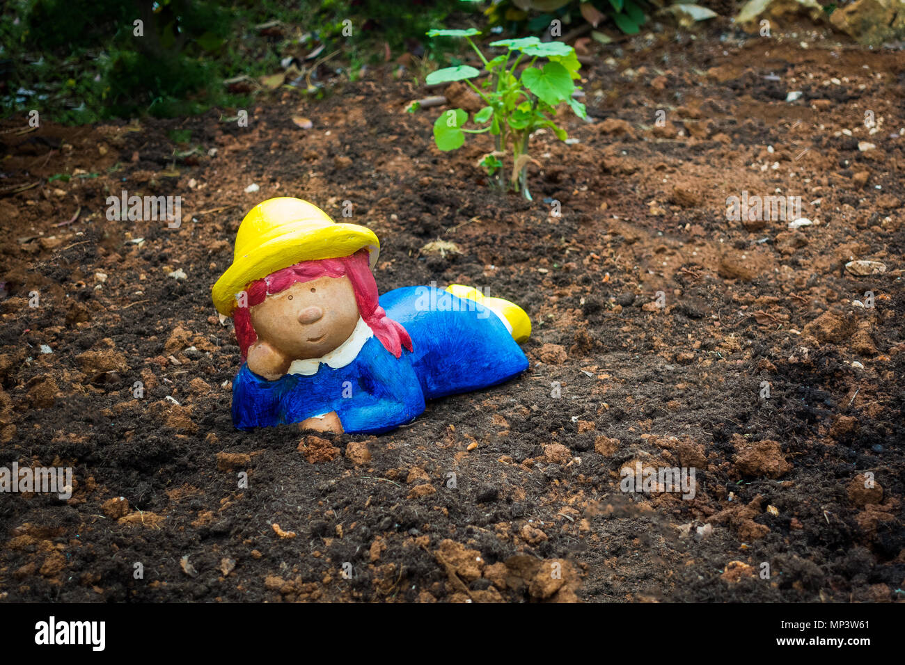 Gnomo da giardino, nano sul suolo, Colorate ragazza come giardiniere Foto Stock