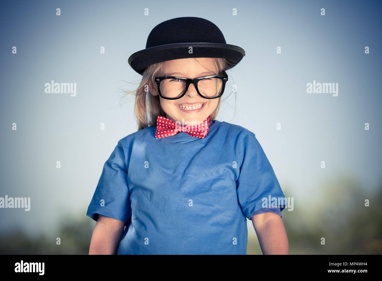 Funny felice bambina a bow tie e cappello bowler. Foto Stock