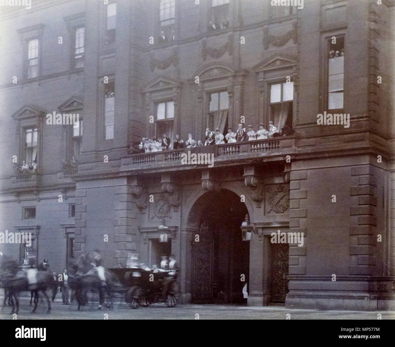 . Inglese: Fotografia della parte anteriore orientale del Buckingham Palace con i membri della famiglia reale tra cui la Regina Victoria (1819-1901) raccolte sul balcone sopra l'ingresso principale per il quadrangolo. Essi guardare un carrello al di sotto, che offuscata dal movimento, lascia il quadrangolo interna, contenente ? Il Duca e la duchessa di York. La fotografia è stata scattata nel giorno del matrimonio . Il 6 luglio 1893. Russell & Sons, Southsea 1182 le nozze tra il Duca e la duchessa di York Foto Stock