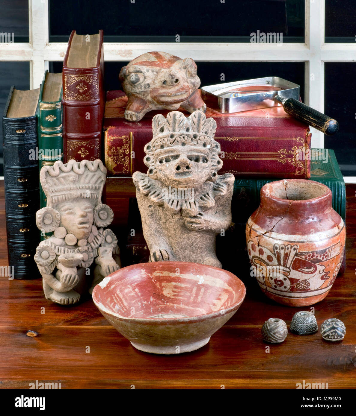 Antique pre colombiana raccolta su tavola con libri antichi. Figurine realizzato intorno al 600 D.C. Foto Stock