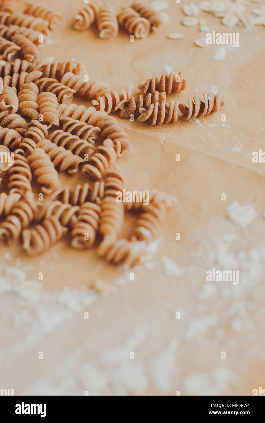 Pasta integrale fusilli da tutto organico farro grano cadendo da un sacchetto di carta Foto Stock