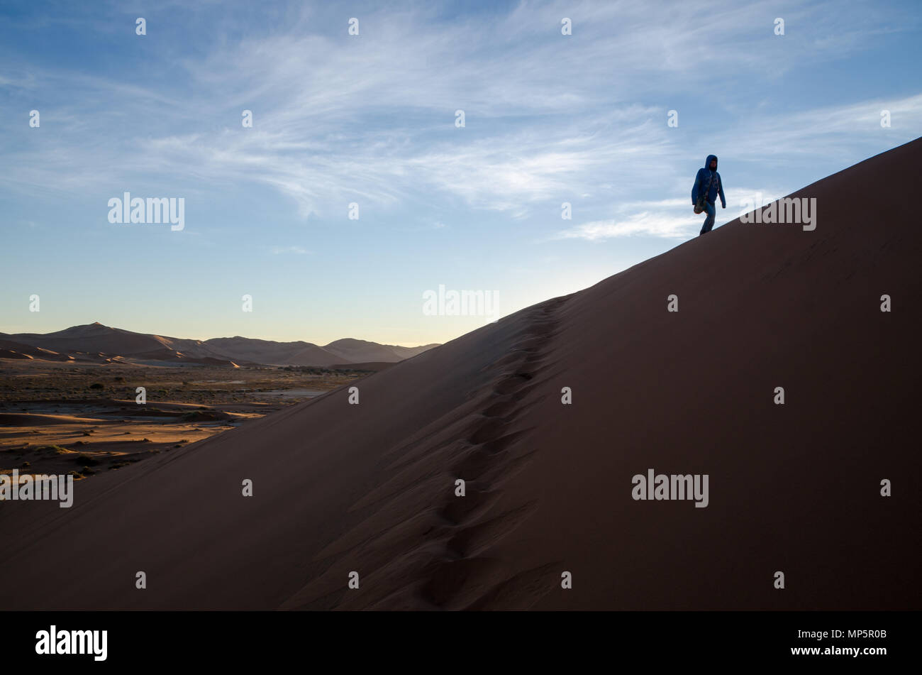 Silhouette non identificabili di persona arrampicata dune di sabbia a Sossusvlei in mattina presto Foto Stock