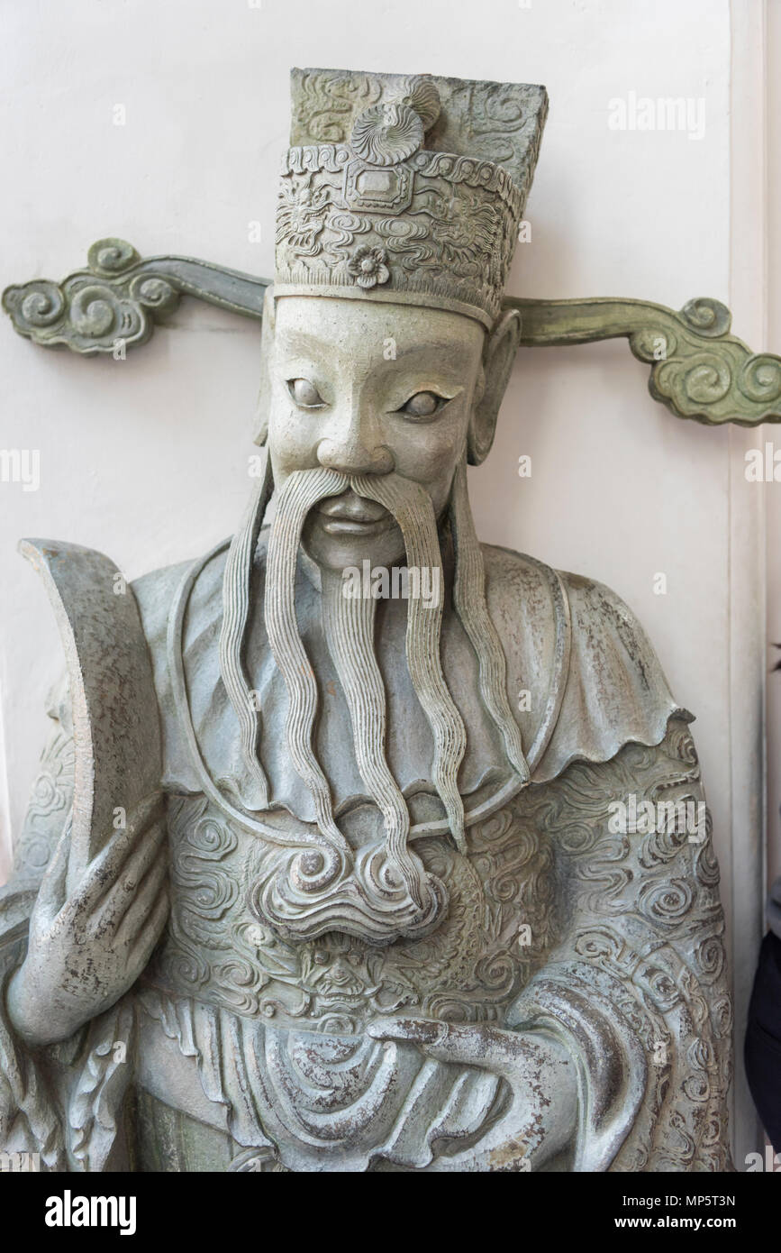 Il volto di una scultura in pietra nella motivazione del Wat Pho (il Tempio del Buddha Reclinato), o Wat Phra Chetuphon Bangkok in Thailandia Foto Stock